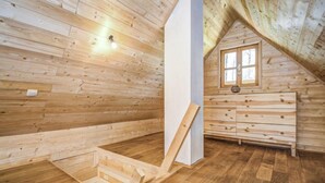 A wooden interior with a sloped ceiling, a window, and a built-in wooden cabinet. - Plitvice II by Interhome (Plitvice)