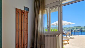 Habitación con vistas al agua, una separación de madera y una ventana que da a un patio.