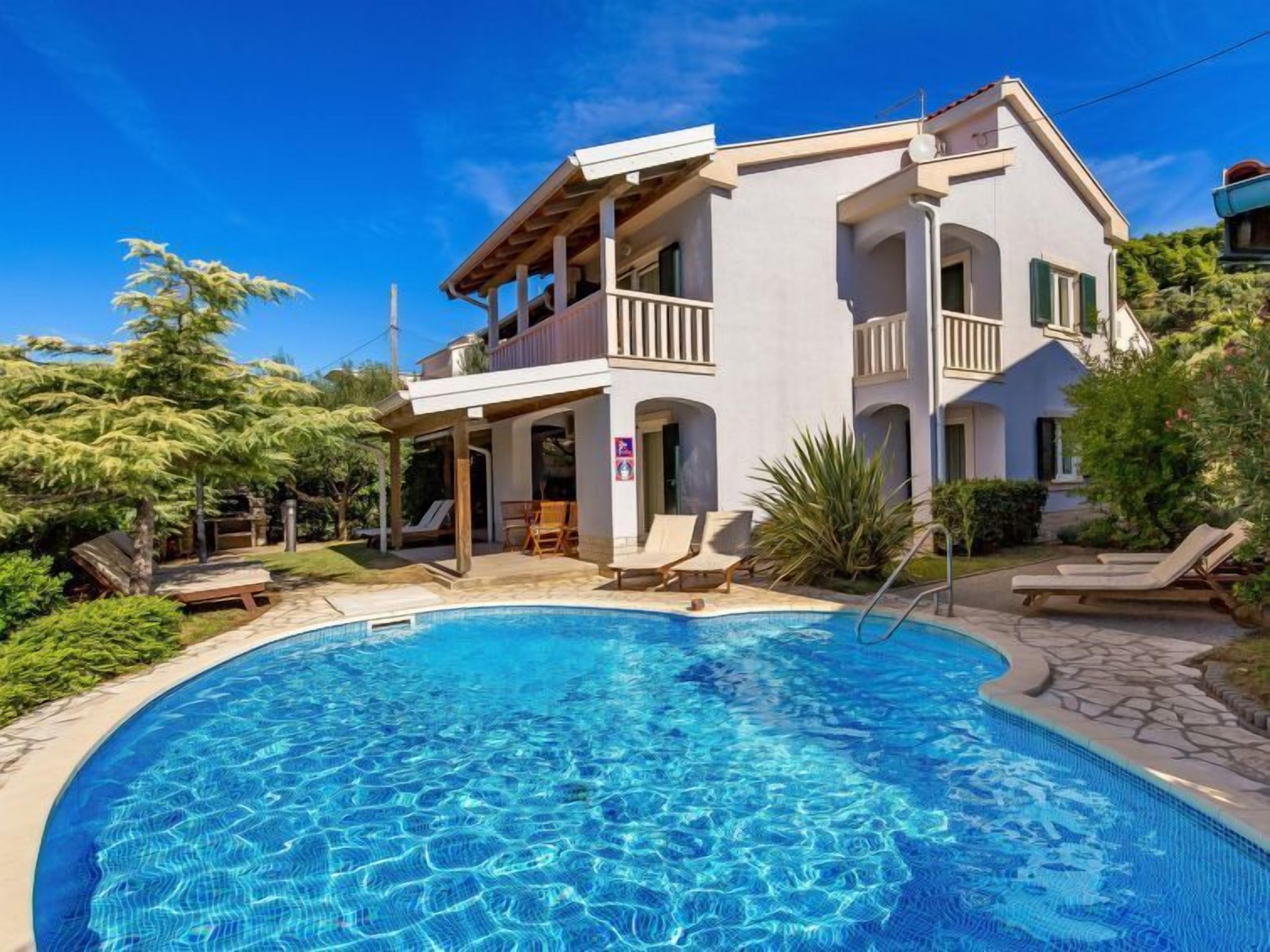 A two-story building with a swimming pool in front.