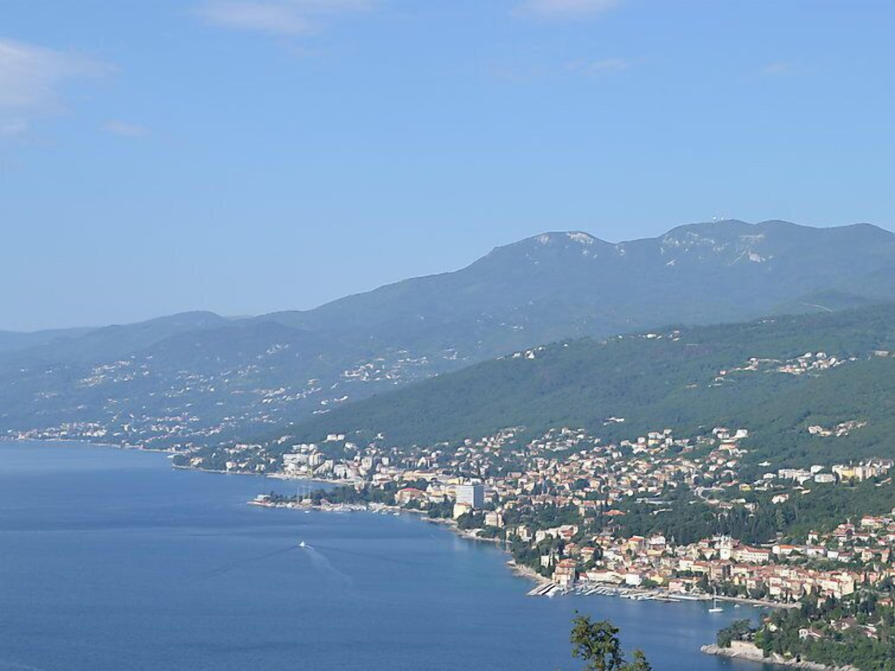 A coastal town with a view of the sea and mountains in the background.