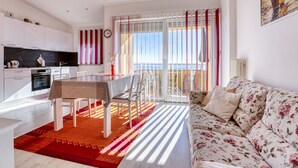 Eine moderne Wohnung mit Küche, Essbereich und einem Balkon mit Blick.