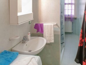Bathroom features a sink, mirror, and shower with a towel rack.