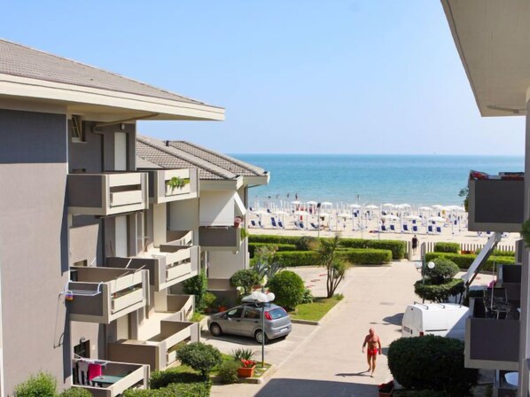 Enjoy stunning views of the beach and sea from this building's upper-floor balcony.