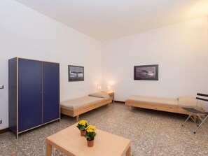A small, clean room with two single beds, a wardrobe, and two framed pictures on the walls. - Aurelia by Interhome (Rome)