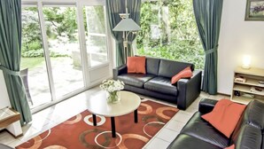 A living room with a sofa, coffee table, and curtains.