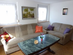 A living room with a sofa, a coffee table, and a painting on the wall. - Apartment Bless by Interhome (Schutterzell)