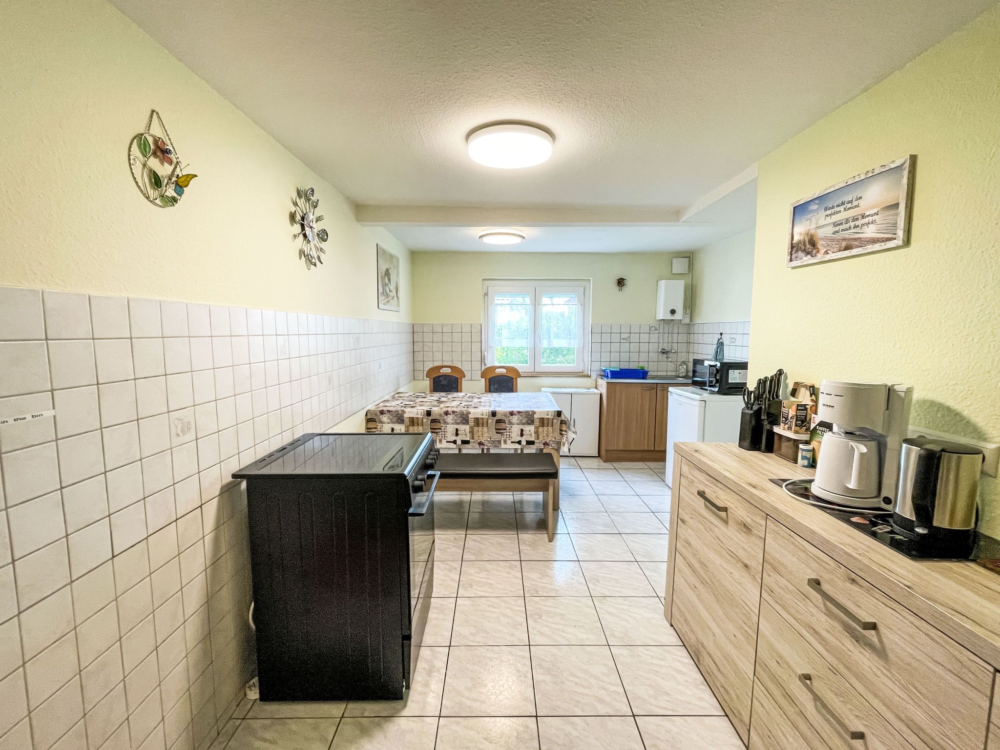 Una cocina compacta con una isla central, un fregadero y un ventanal.