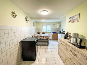 A compact kitchen with a central island, a sink, and a window. - Apartment Bless by Interhome (Schutterzell)