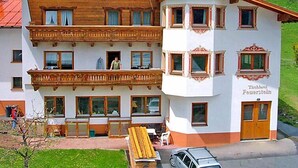 A two-story building with a balcony and a sign reading "Tischlerei Feuerstein". - Apartment Werner by Interhome (Pettneu am Arlberg)