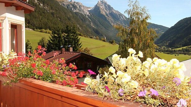 A mountain view with a wooden balcony and flower beds. - Apartment Werner by Interhome (Pettneu am Arlberg)