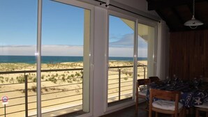 A room with a large sliding glass door leading to a beach view. - Apartment Capama by Interhome (Mimizan)