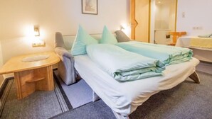 A bedroom with a bed, bedside table, and a mirror. - Christian by Interhome (Pettneu am Arlberg)