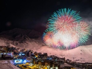 Une ville de montagne enneigée, avec des bâtiments et une piste de ski.
