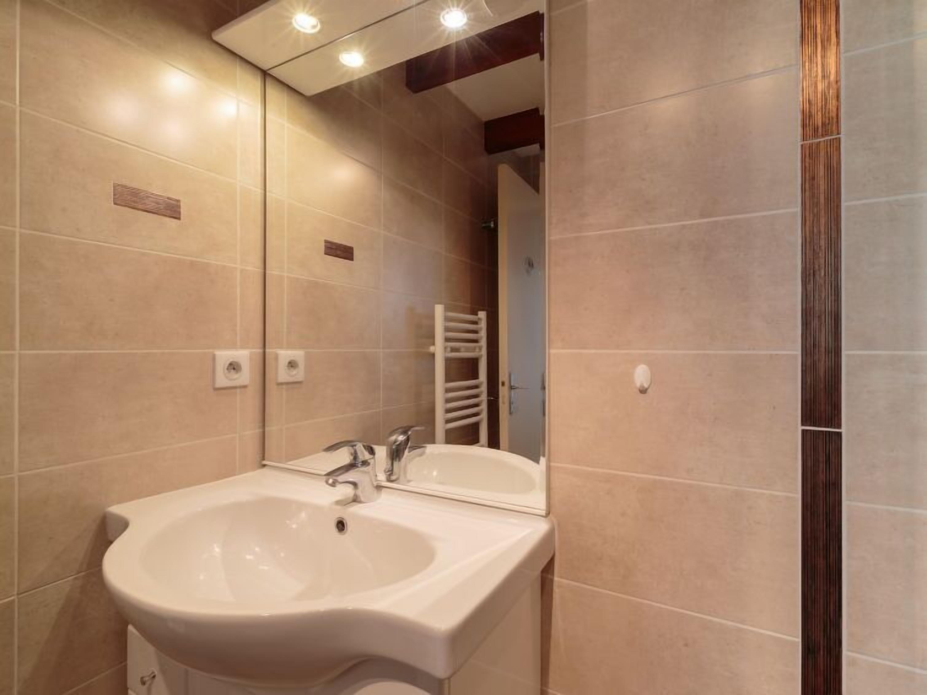 Een badkamer met twee wastafels, een spiegel en een handdoekhouder.
