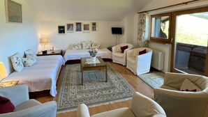 A spacious living room with a high ceiling, a large window, and a cozy seating area with a coffee table. - Kaiserhof by Interhome (Alpbach)