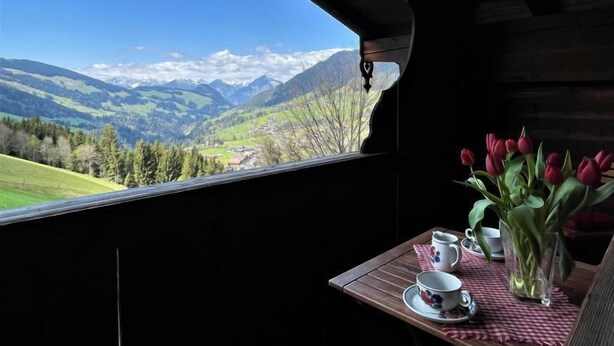 A table with a view of a mountainous landscape through a window. - Kaiserhof by Interhome (Alpbach)