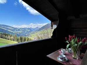 A table with a view of a mountainous landscape through a window.
