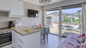 A compact kitchen with a dining area and a balcony with a view of the town.