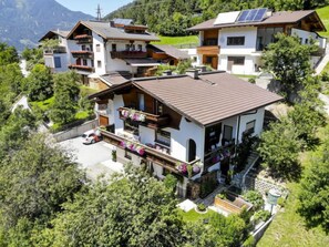 A modern chalet with multiple balconies, solar panels, and a well-maintained garden.