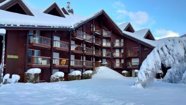 A wooden lodge with multiple balconies and a snow-covered landscape. - Pierres Blanches F et H by Interhome (Les Contamines)