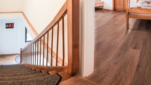 A staircase with wooden railings leading to a bedroom with a bunk bed. - Lanovka by Interhome (Jachymov)