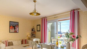 A dining area with a table, chairs, a sofa, and a bookshelf. - Les Villas de Kermaria by Interhome (Quiberon)