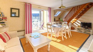 A cozy living room with a dining area, a staircase, and a TV. - Les Villas de Kermaria by Interhome (Quiberon)