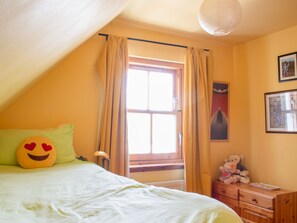 A bedroom with a bed, a window with curtains, a teddy bear, and a lamp. - Staffin Road by Interhome (Mid Skye)