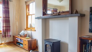 Ein gemütliches Wohnzimmer mit Kamin, Holzmöbeln und einer Bücherwand.
