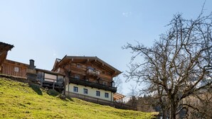 A traditional chalet with a sloped roof, wooden balconies, and a stone chimney. - Mooslehen by Interhome (Kaprun)