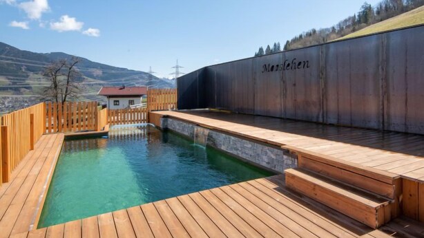 A spa area with a wooden deck, a small pool, and a building labeled "Manslehen" in the background. - Mooslehen by Interhome (Kaprun)