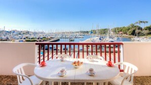 A balcony with a table set for two, overlooking a marina with boats and a clear blue sky. - Le Grand Pavois by Interhome (Capbreton)