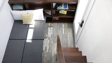 A staircase leading to a lower level with a built-in seating area and a shelf with various items.