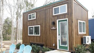 A small wooden cabin with a green door, two windows, and a sign reading "The Elizabeth."