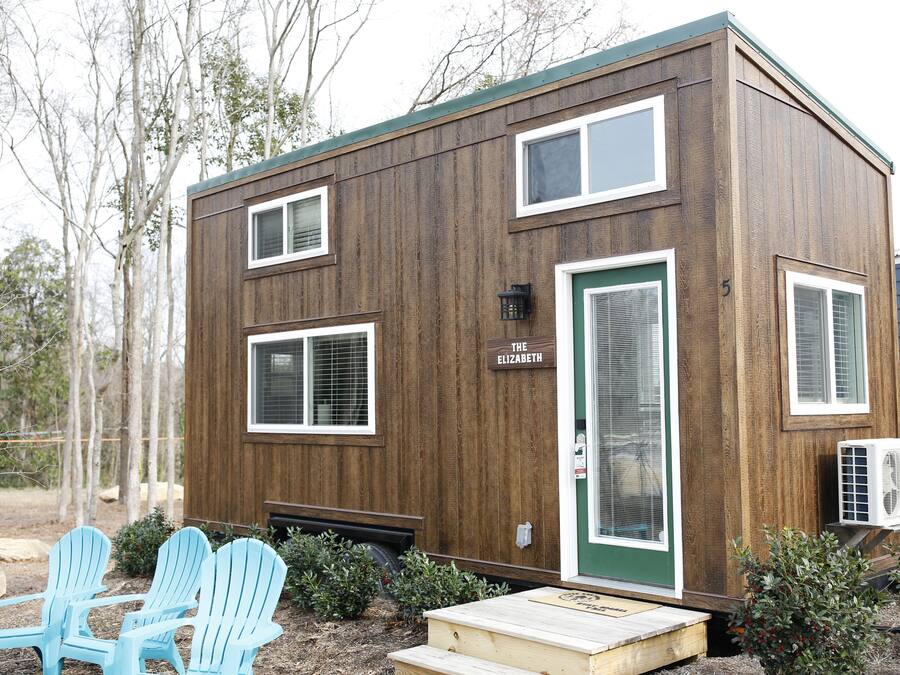 A small wooden cabin with a green door, two windows, and a sign reading "The Elizabeth."