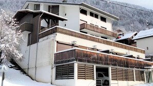 A multi-story building with balconies, a garage, and a snowy landscape. - Le Sporting by Interhome (Saint Gervais)