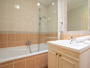 Ein Badezimmer mit einer Badewanne, einem Waschbecken und einer Dusche.