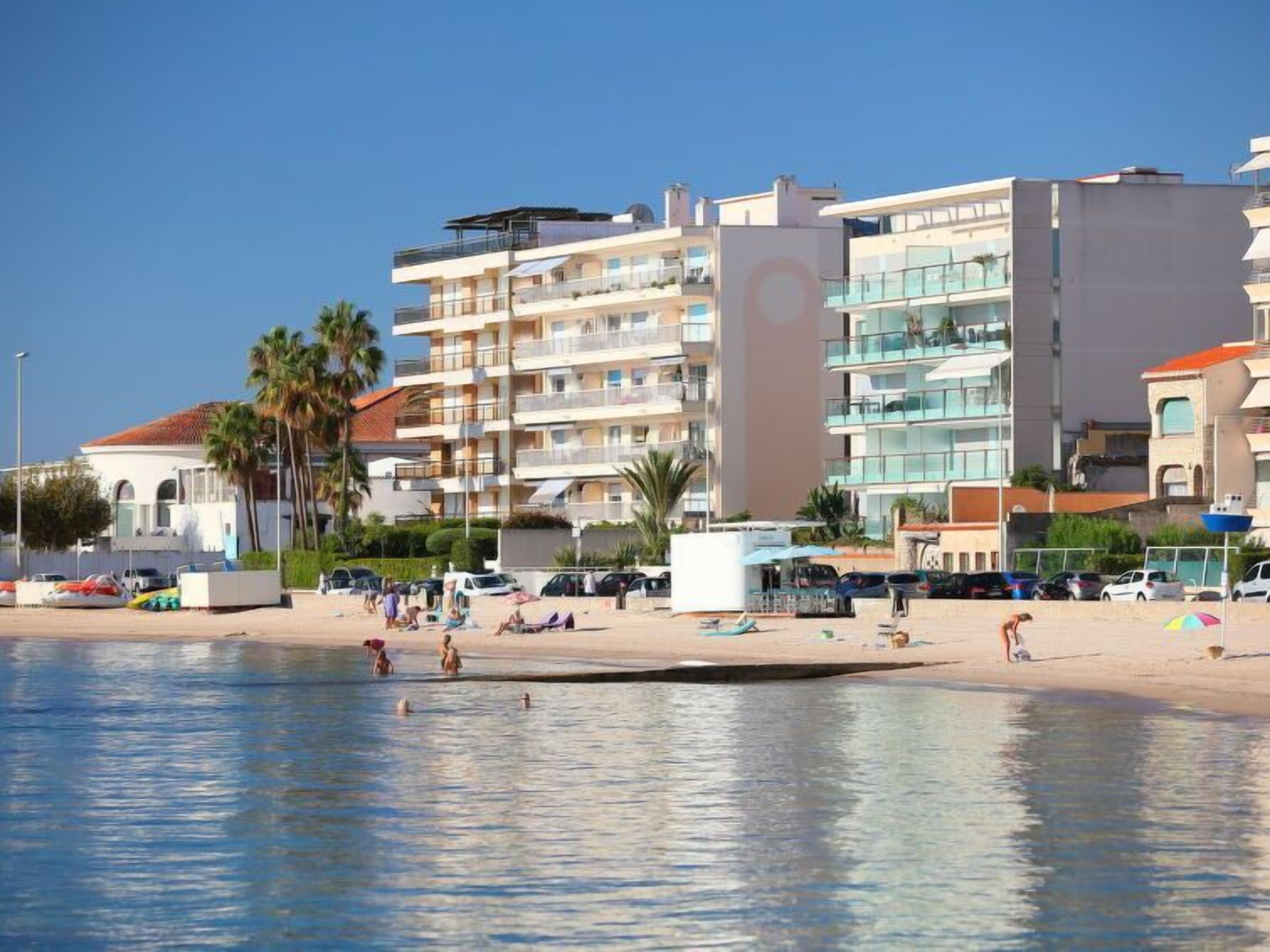 A beachfront hotel with multiple balconies, a swimming pool, and beachside amenities.