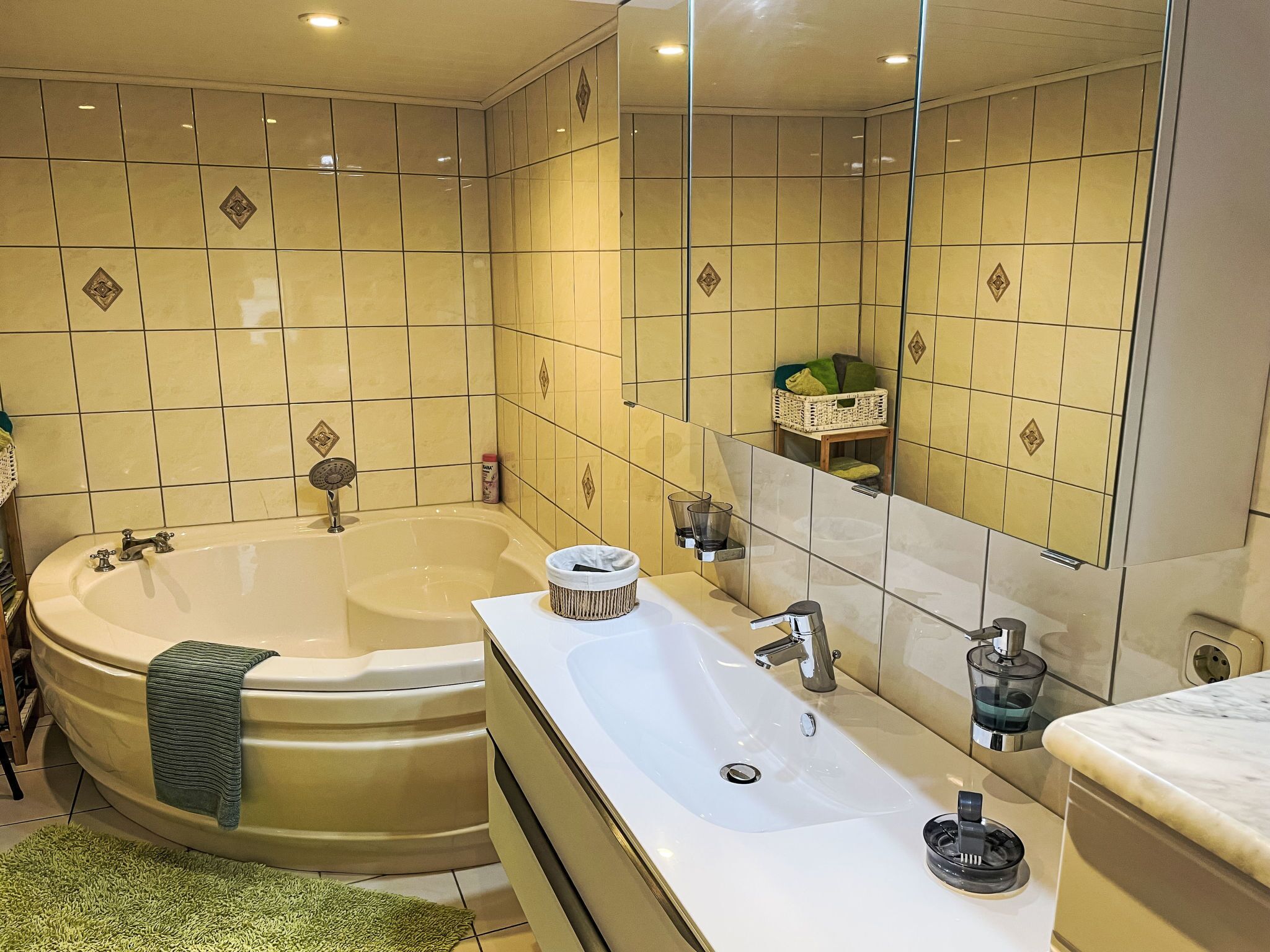 Een badkamer met een bad, een wastafel en een spiegel.