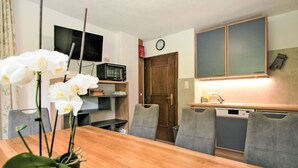 A compact kitchen with a microwave, a clock, and a wooden door. - Obernberg by Interhome (Obernberg am Brenner)