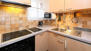 Une cuisine compacte équipée d’un four à micro-ondes, d’une cuisinière et d’un évier.