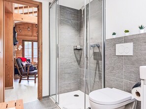A modern bathroom with a glass-enclosed shower, a toilet, and a small potted plant on the wall. - Bergkristall Apt. P by Interhome (Wengen)