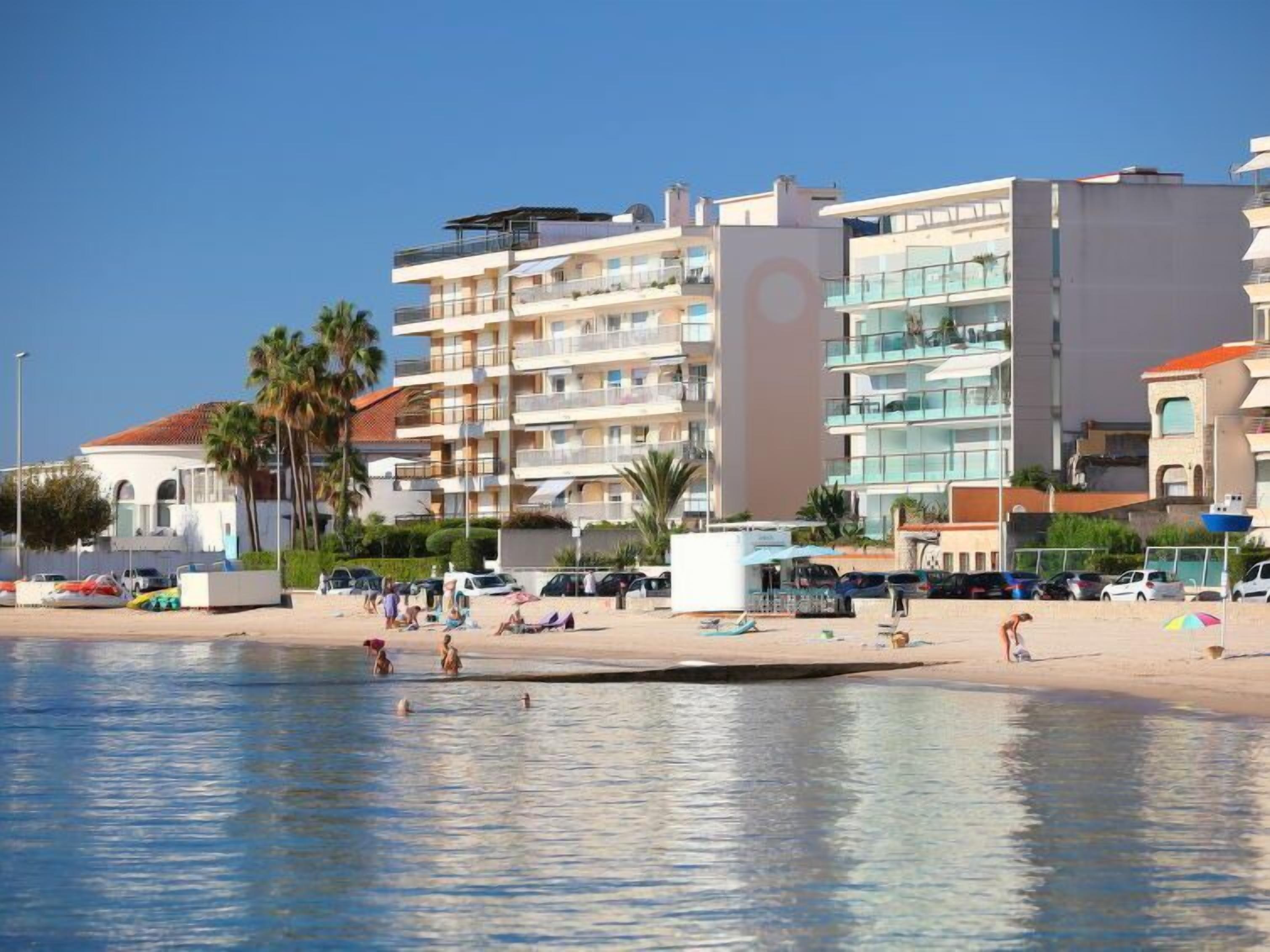 A beachfront hotel with multiple balconies, a swimming pool, and beachside amenities.