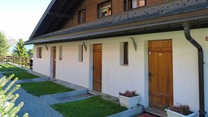 Un bâtiment à deux étages, doté d’un toit en pente, d’une façade en bois et de nombreuses fenêtres.