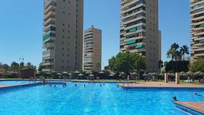 Piscina rodeada por edifícios residenciais altos com varandas.