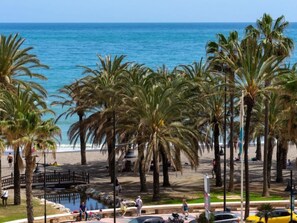 A beach with palm trees, a small bridge, and a view of the ocean. - Playamar by Interhome (Torremolinos)
