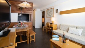 Un espacio habitable compacto con comedor, kitchenette y sofá.
