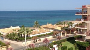 Un área residencial costera con edificios que dan al mar, con balcones, jardines y una vista despejada del océano.