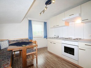 A compact kitchen with white cabinets, a built-in oven, and a sink.