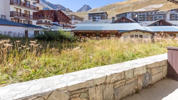 A mountain resort with chalet-style buildings, stone walls, and a clear view of the surrounding mountains. - Chalet Club (Val Claret) by Interhome (Tignes)